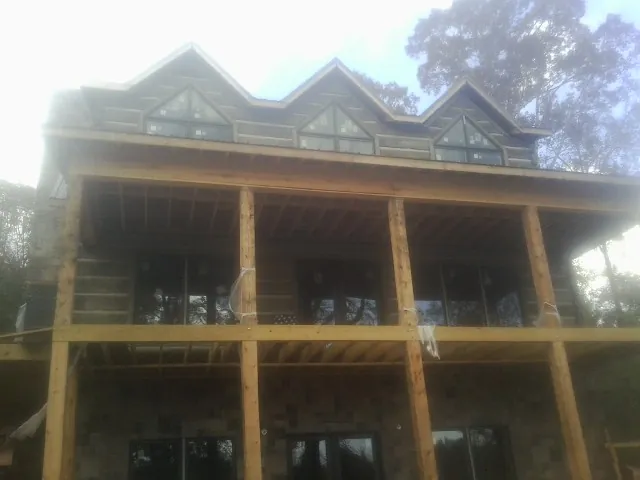 Dormers and porch framing on a large log home under construction in Addy