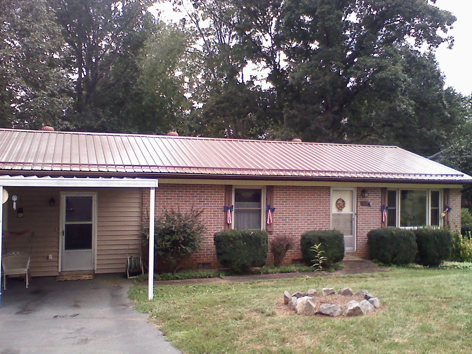 Bronze metal roof and carport on a brick ranch home — Roof Repair work by our crew in Addy